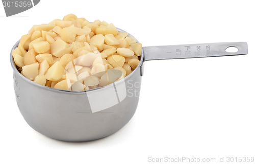 Image of Chopped macadamia nuts in a cup measure