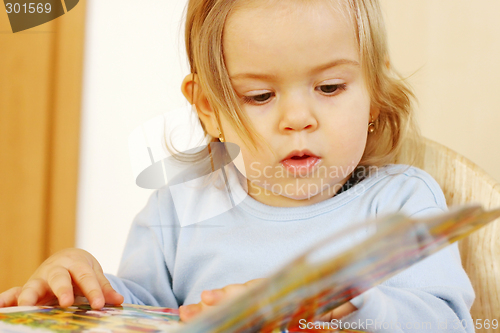 Image of Small baby reading a book