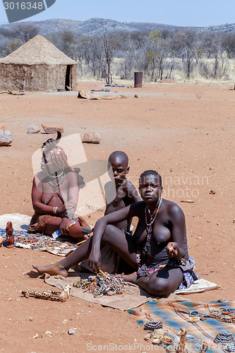 Image of Himba and Zemba girl with souvenirs for sale in traditional vill