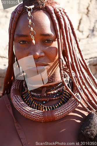 Image of Himba woman with ornaments on the neck in the village