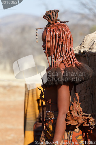 Image of Himba woman with ornaments on the neck in the village