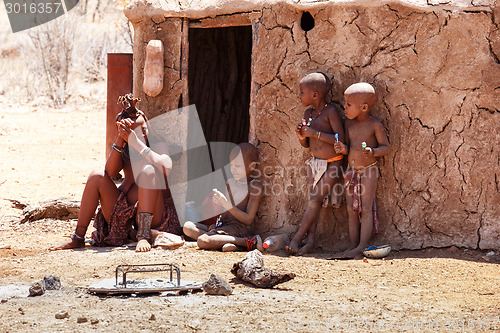 Image of Himba woman with childs on the neck in the village