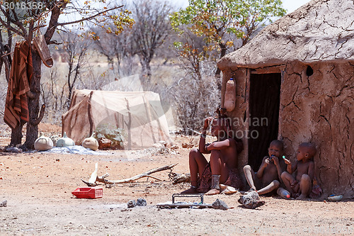 Image of Himba woman with childs on the neck in the village