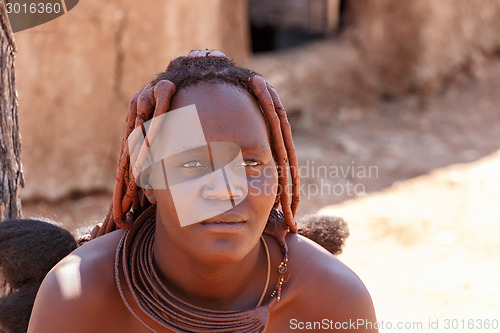 Image of Himba woman with ornaments on the neck in the village