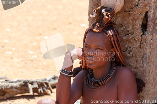 Image of Himba woman with ornaments on the neck in the village