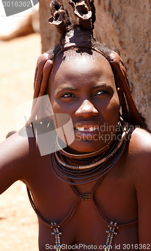 Image of Himba woman with ornaments on the neck in the village