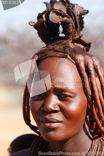 Image of Himba woman with ornaments on the neck in the village