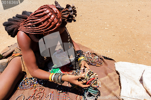 Image of Himba girl with souvenirs for sale in traditional village