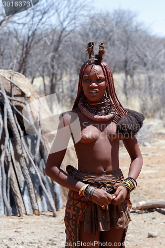 Image of Himba woman with ornaments on the neck in the village