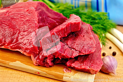 Image of Meat beef with herbs on wooden board