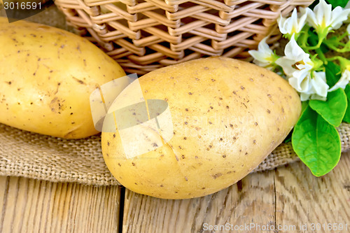 Image of Potatoes yellow with flower and basket on board