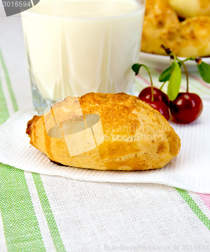 Image of Patty with cherries and milk on tablecloth