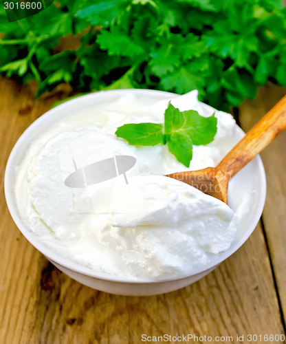 Image of Yogurt in white bowl with mint and herbs on board