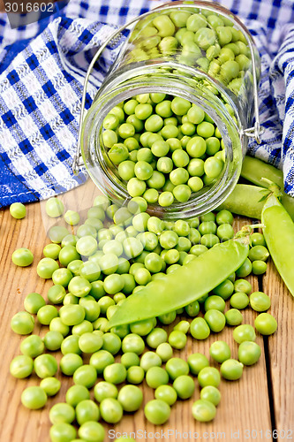 Image of Green peas in glass jar with cloth on board