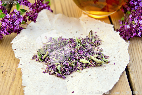 Image of Oregano is dry on the paper with cup on board