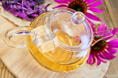 Image of Tea from Echinacea in glass teapot on board