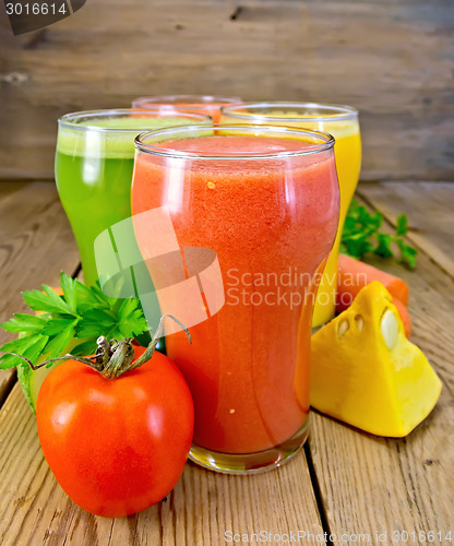 Image of Juice tomato and vegetables in glasses on board