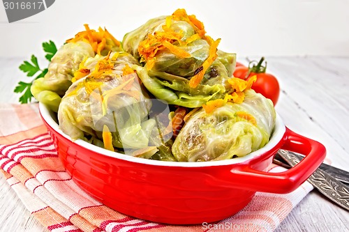 Image of Cabbage stuffed and carrots in pan on board