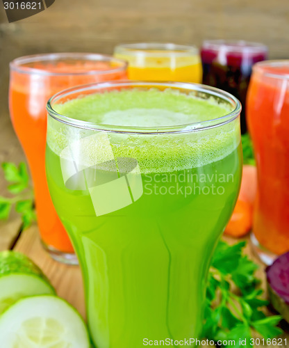 Image of Juice cucumber and vegetable in glass with vegetables on board