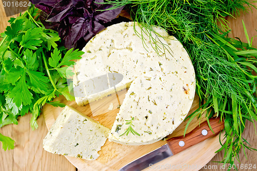 Image of Cheese homemade round with greens on board