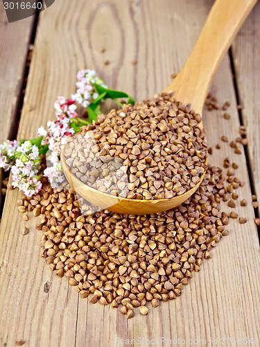 Image of Buckwheat in wooden spoon with flower on board