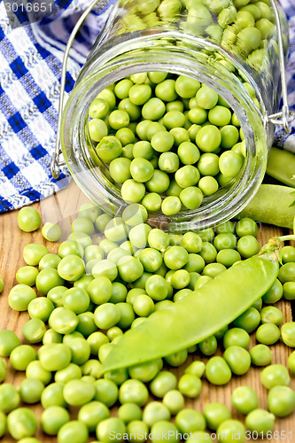 Image of Green peas in glass jar on board