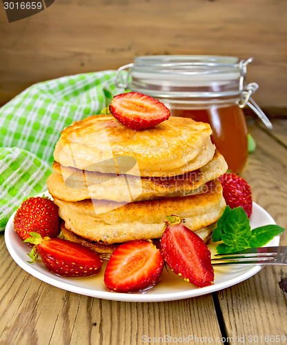 Image of Flapjacks with strawberries and honey on board