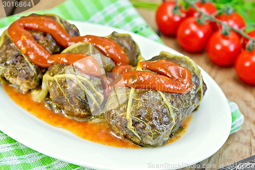 Image of Rhubarb leaves stuffed in plate with sauce on board