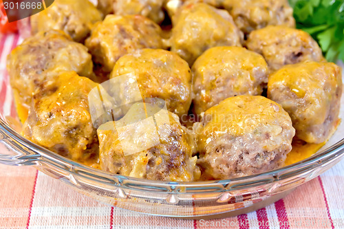 Image of Meatballs with sauce in glass pan on tablecloth