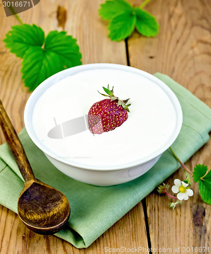 Image of Yogurt thick with strawberries in bowl on board