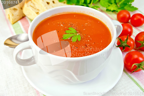 Image of Soup tomato with peppers in bowl on linen napkin