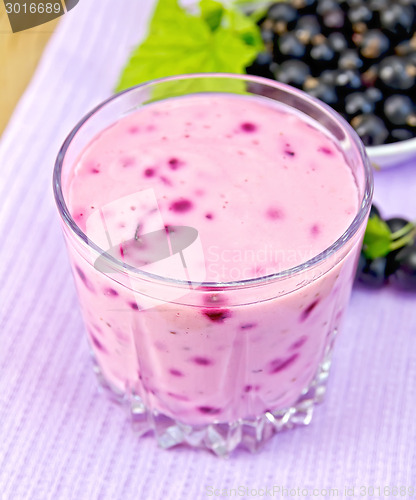 Image of Milkshake with blackcurrants on purple napkin