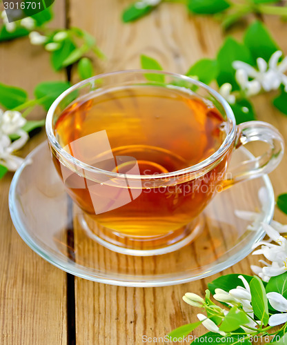 Image of Tea with white flowers of honeysuckle on board