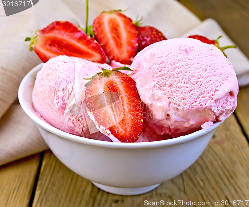 Image of Ice cream strawberry in bowl on board with cloth