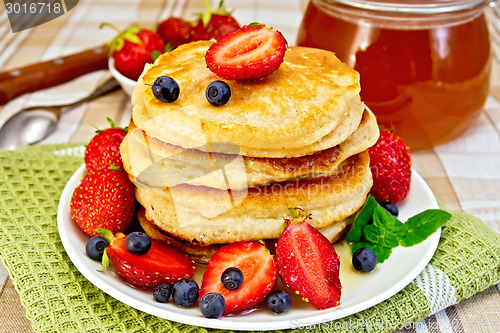 Image of Flapjacks with strawberries and blueberries on napkin