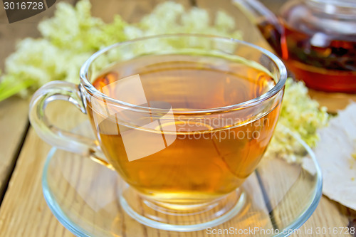 Image of Tea from meadowsweet in glass cup and teapot on board