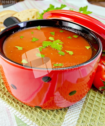 Image of Soup tomato in red ware on napkin