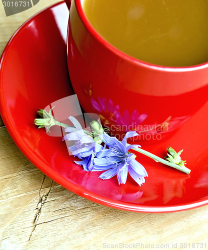 Image of Chicory drink in red cup and flower on board