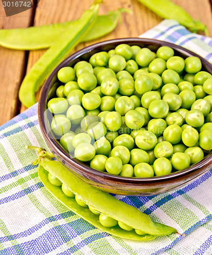 Image of Green peas in brown bowl on checkered napkin