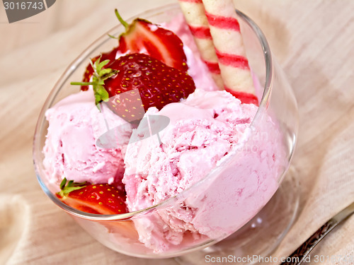 Image of Ice cream strawberry in glass bowl with waffles on fabric