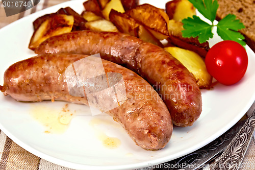 Image of Sausages pork fried with potatoes and tomato on plate