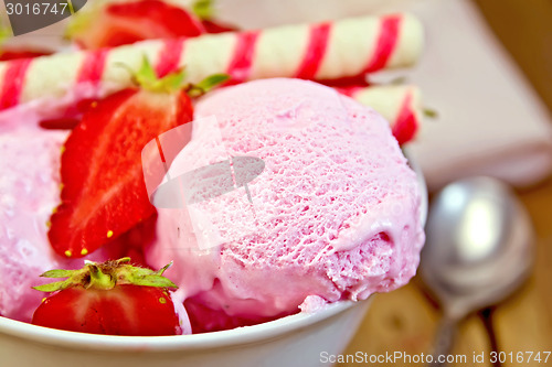 Image of Ice cream strawberry in bowl with waffles on board