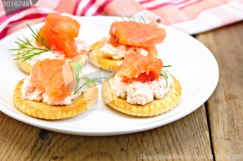 Image of Crackers with cream and salmon on board
