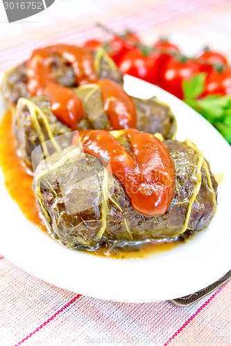 Image of Rhubarb leaves stuffed in plate with sauce on fabric