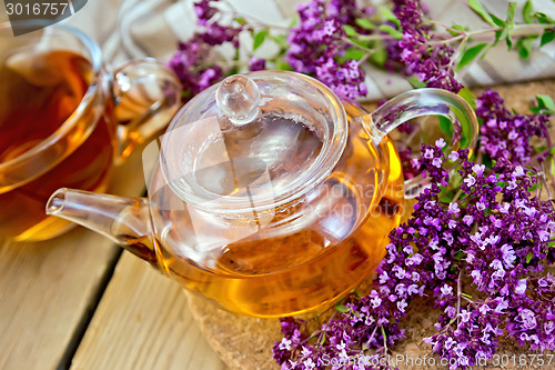 Image of Tea of oregano in glass teapot on board