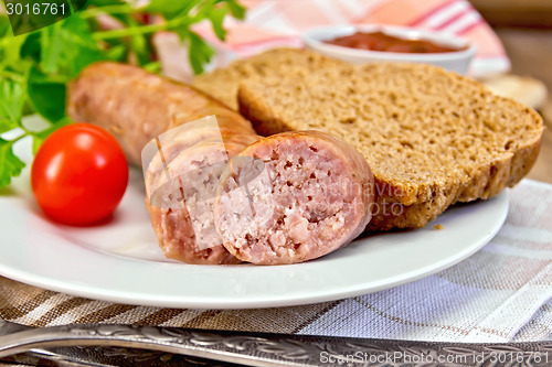 Image of Sausages pork grilled in plate with bread on napkin