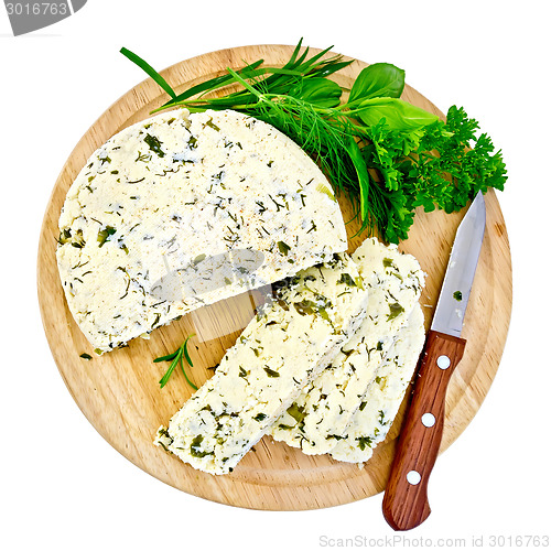 Image of Cheese homemade with knife and herbs on round board