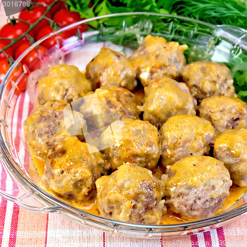 Image of Meatballs with sauce in glass pan on fabric