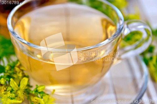 Image of Tea from tutsan in glass cup on tablecloth