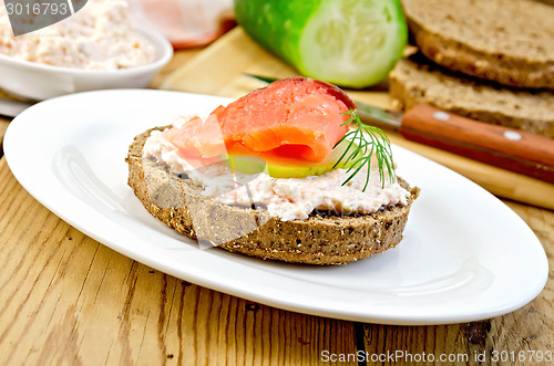 Image of Sandwich with cream and salmon in oval plate on board
